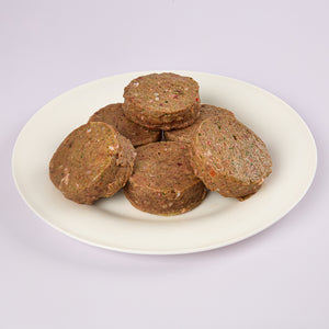 Six Puppy Power raw dog food patties on a white plate from LUNA & me