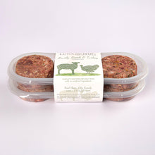 Two stacked plastic containers filled with LUNA & me Lovely Lamb & Turkey raw dog food patties