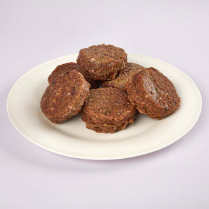 Six Senior's Club raw dog food patties on a white plate from LUNA & me