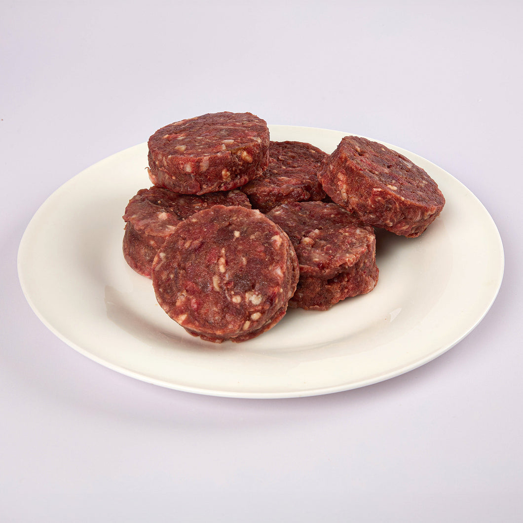Six Beef raw dog food patties on a white plate from LUNA & me