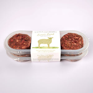 Two stacked plastic containers filled Luna's Lamb raw dog food patties