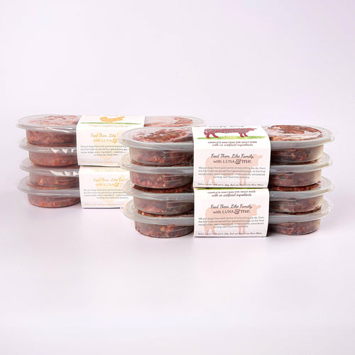 Four stacked plastic containers filled with LUNA & me Weekly Favourites raw dog food patties